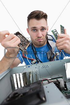 Portrait of confused it professional with chips in front of open cpu
