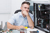 Thoughtful hardware professional sitting by an open cpu