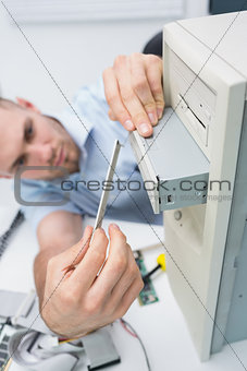Computer engineer fixing cddvd player into computer case