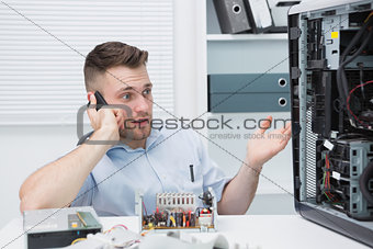 Computer engineer on call as he gestures towards an open cpu