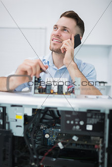 Computer engineer working on cpu part while on call in front of open cpu
