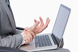 Business man with wrist pain while using laptop