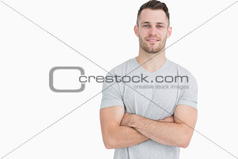 Portrait of casual young man standing with arms crossed