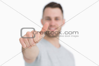 Casual young man gesturing thumbs up