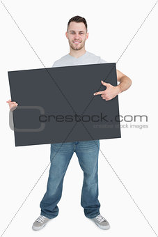 Portrait of young man showing something on blank card