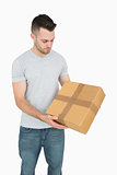 Young casual man carrying cardboard box