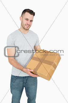 Portrait of young man carrying cardboard box