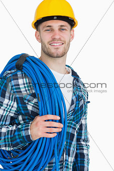 Portrait of smiling young male architect carrying coiled blue tubing