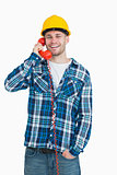 Portrait of young male architect using landline phone
