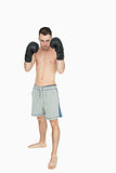 Portrait of shirtless young boxer in shorts