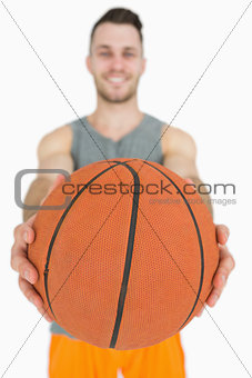 Portrait of happy young man holding basketball