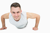 Portrait of smiling young man doing push ups