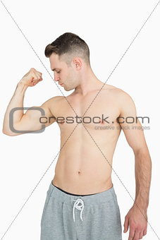Shirtless young man flexing muscles