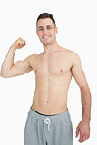 Portrait of shirtless young man flexing muscles