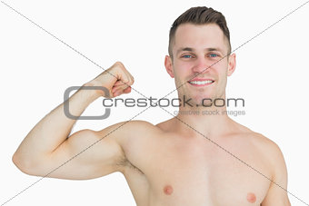 Portrait of shirtless young man flexing muscles