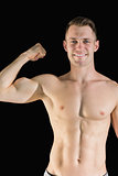 Portrait of smiling young man flexing muscles
