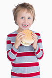 Cute happy young boy holding burger