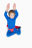 Boy dressed as superhero and raising arms