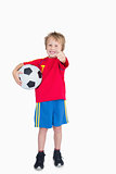 Portrait of boy with football gesturing thumbs up