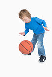 Young casual boy playing basketball
