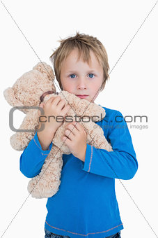 Portrait of cute young boy hugging teddy bear