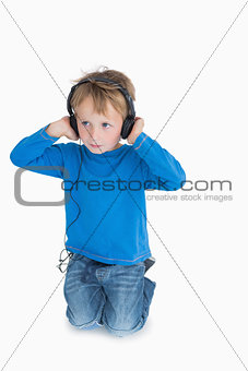 Young boy listening music through headphones