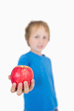 Young boy holding out a apple