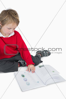 Little boy sitting and reading book
