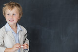 Boy dressed as teacher standing in front of black board