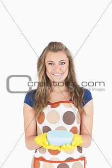 Portrait of smiling young maid holding sponge