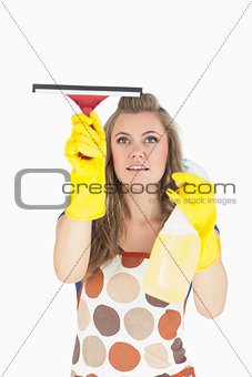 Maid in yellow gloves using wiper and disinfectant spray