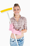 Portrait of casual young woman holding broom
