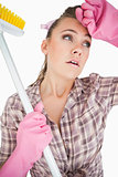 Tired young woman holding broom