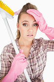 Portrait of tired young woman holding broom