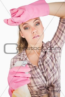 Portrait of tired young woman holding spray bottle