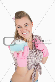 Portrait of happy woman holding soap suds over sponge