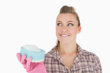 Smiling woman holding soap suds over sponge