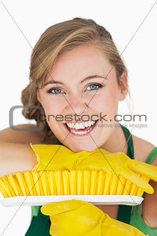 Closeup portrait of cheerful woman with broom
