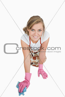 Young maid cleaning floor over white background
