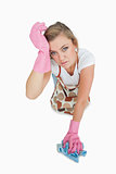 Portrait of tired young woman cleaning floor