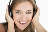 Closeup of young woman listening music through headphones