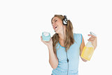 Woman with sponge and spray bottle enjoying music over headphones