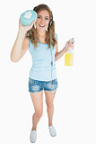 Woman with sponge and spray bottle listening music over headphones