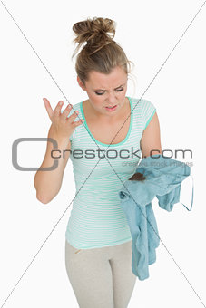 Disgust young woman looking at stained shirt
