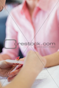 Woman filing fingernail