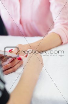 Woman filing fingernail