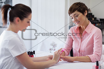 Woman getting manicure in nail salon
