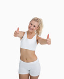 Happy woman in sportswear giving thumbs up