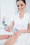 Manicurist filing womans nails