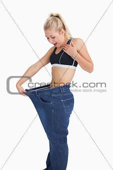 Young thin woman wearing old pants after losing weight